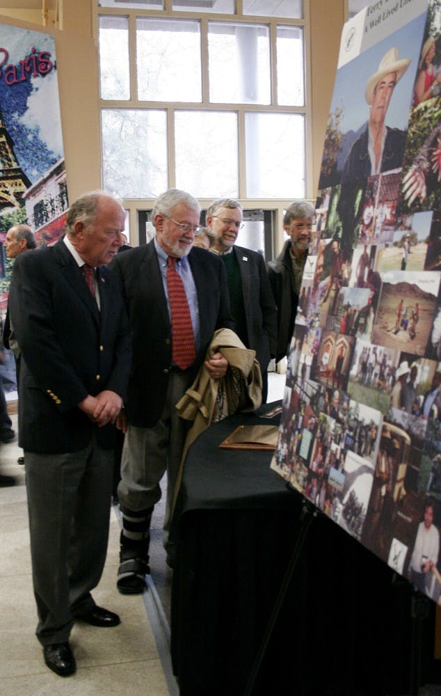 Coleman Travelstead, left, and Sherman McCorkle look at photographs of Terry Yates during a memorial service on Dec. 14 in Popejoy Hall. Yates, who was UNM's vice president for Research and Economic Development, died Dec. 11. He was 57.