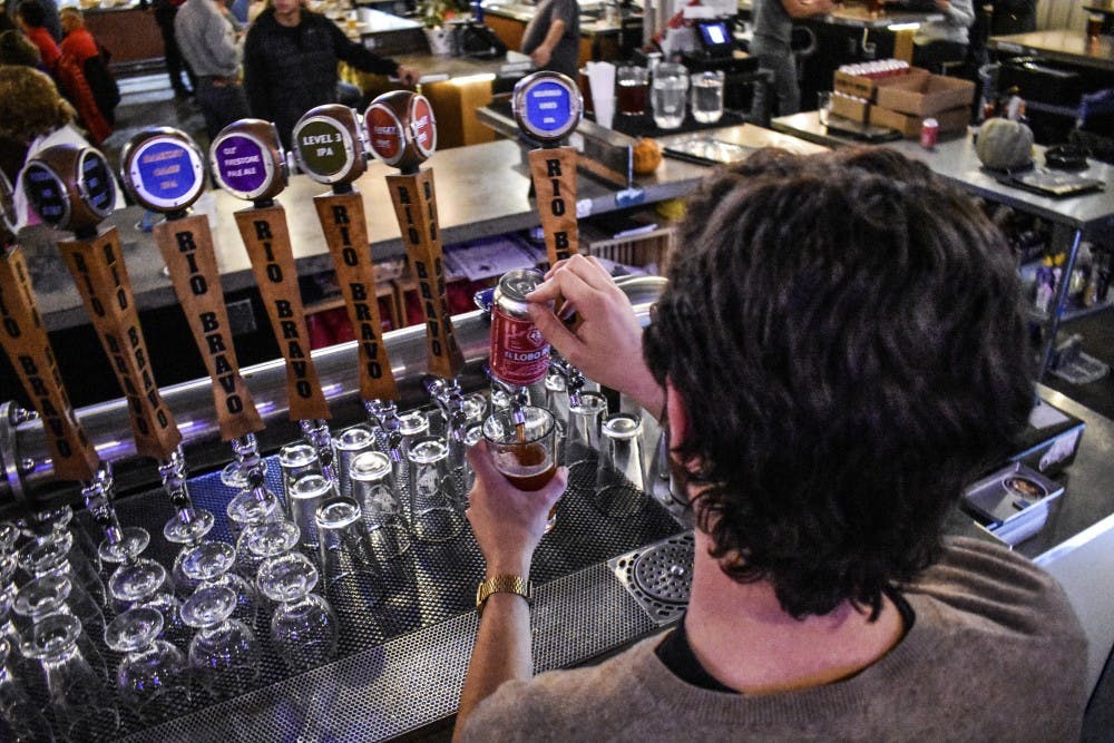 A bartender at the Rio Bravo Brewing Company pours a new beer, the Lobo Rojo.