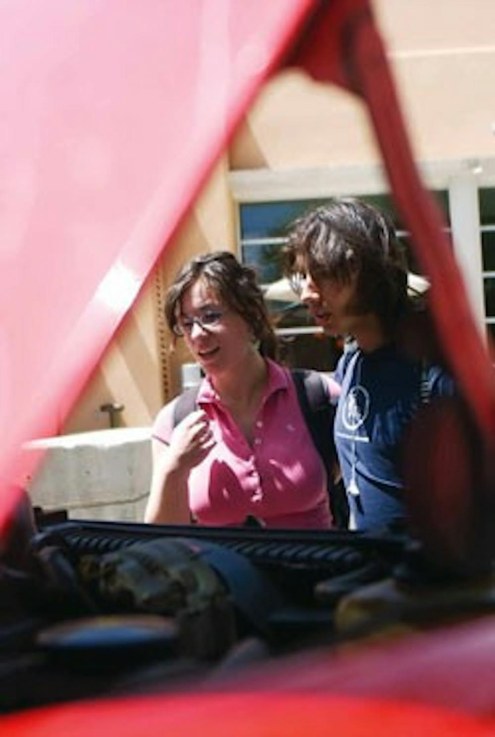 Rebecca Sigal and Joel Garcia look at a truck that was converted to run on biodiesel. The truck was part of the Albuquerque Alternative Energies Fair held in Cornell Mall on Monday.