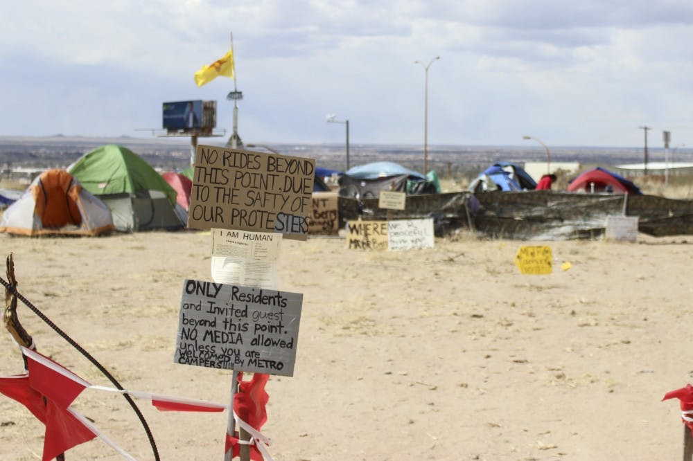 Signs are posted in front of Camp Resurrection during its short term location on a plateau on Lomas Blvd and I-40 in March of 2015.