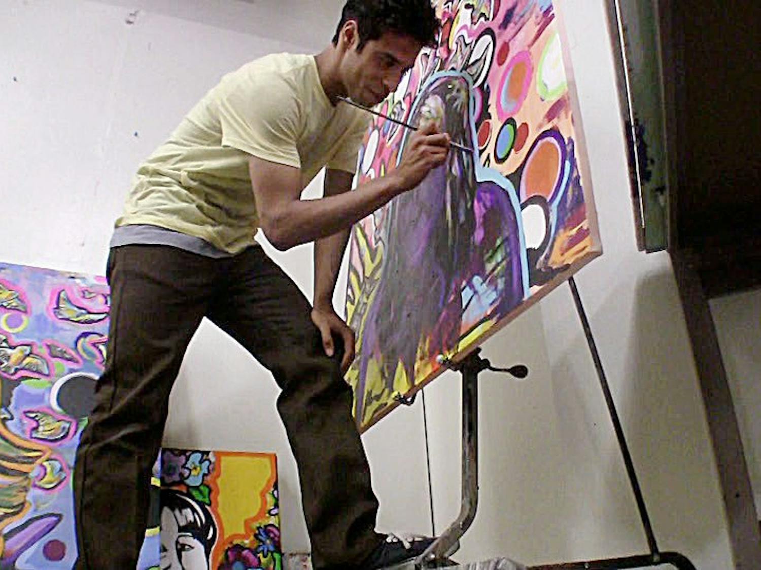 	Allen Colmenares, an art undergraduate, works on a painting of his mother at the Art Building.