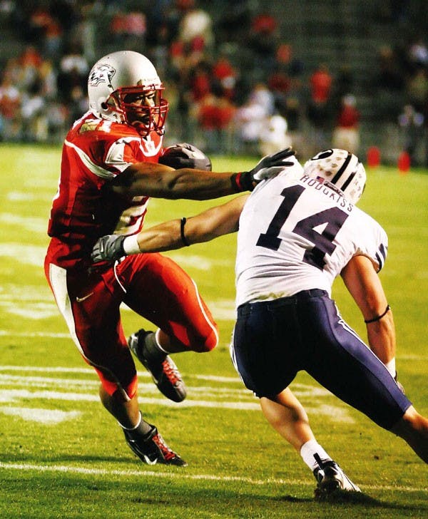 UNM's Rodney Ferguson runs past BYU's Corby Hodgkiss before scoring in the third quarter at University Stadium on Saturday.  