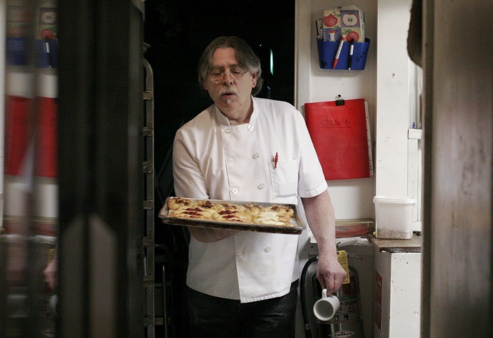 	Gary Cline removes cherry and pecan Danishes from the oven at the Chocolate Cafe and Bakery on Monday.  