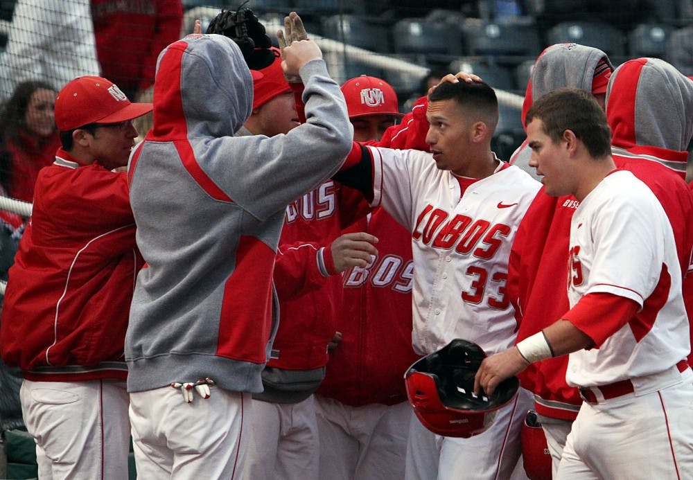 	Ryan Honeycutt trots toward the dugout and high-fives teammates Friday after hitting a grand slam in the third inning against San Diego State at Isotopes Park. The Lobos won 5-4 on Sunday to sweep the three-game series.