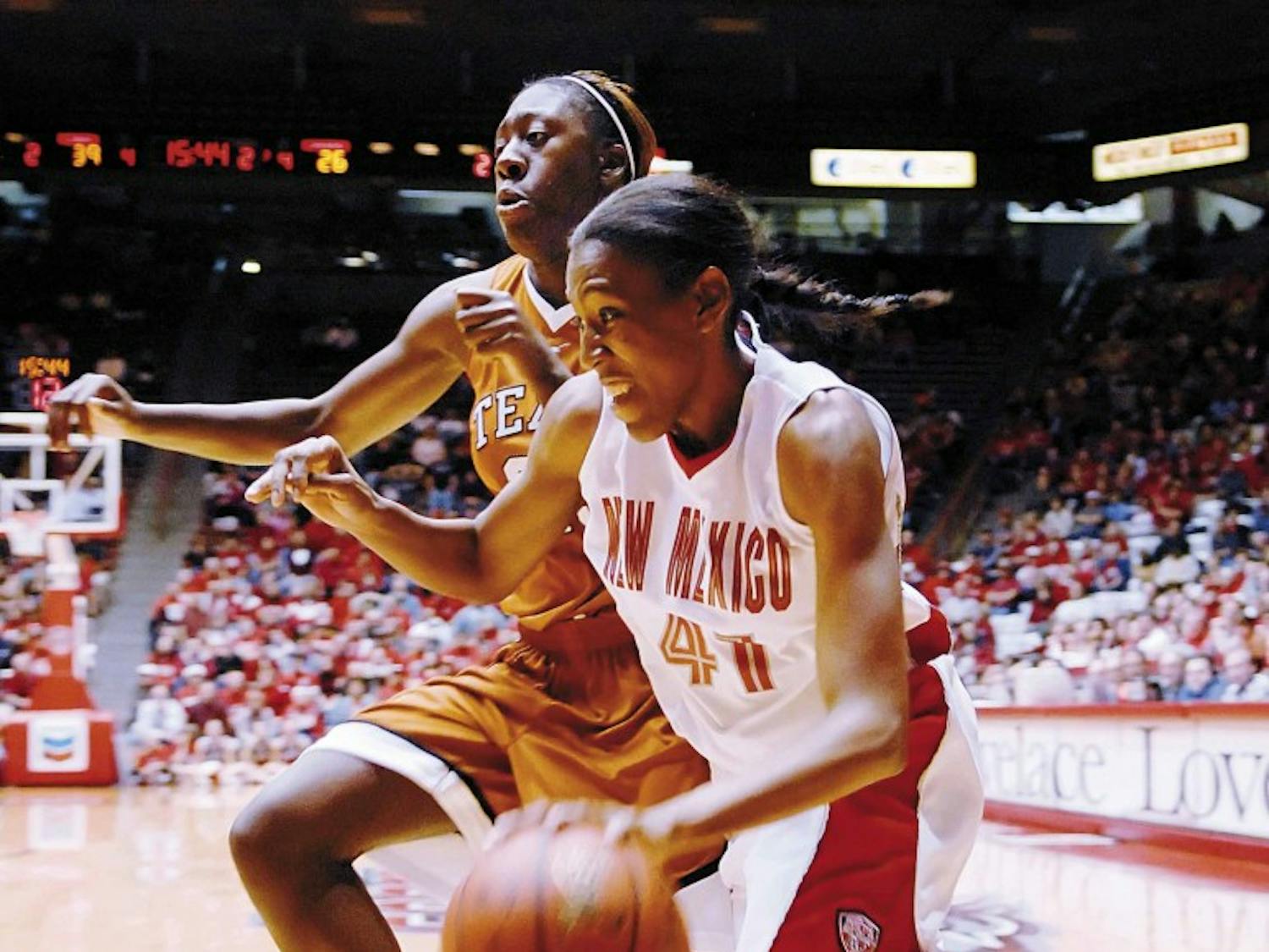 UNM guard Brandi Kimble drives toward the basket as Longhorns' Niqky Hughes defends during the Lobos' 63-60 win at The Pit on Friday.