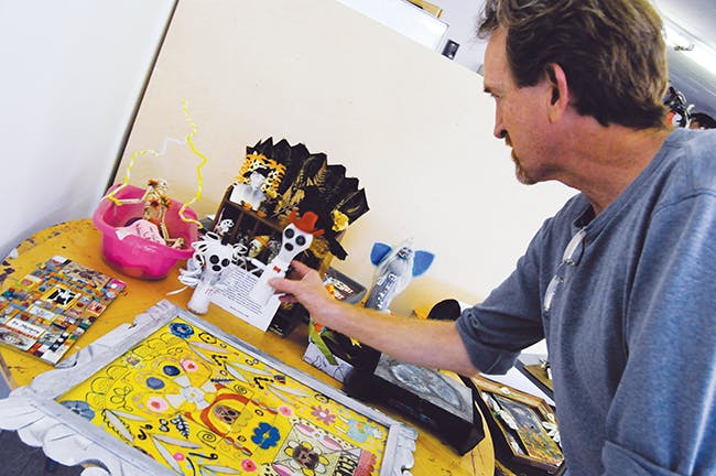 Director of OFFCenter Community Arts Project, Ron Breen, sets up a display for Dia de los Muertos. 