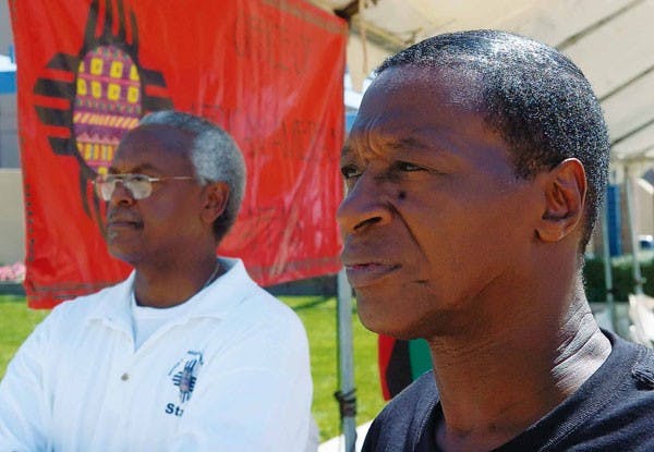 Former ASUNM President Sam Johnson, right, and Harold Bailey, executive director of the New Mexico Office of African-American Affairs, listen to a speaker at the Black Expo at Civic Plaza on Saturday. 