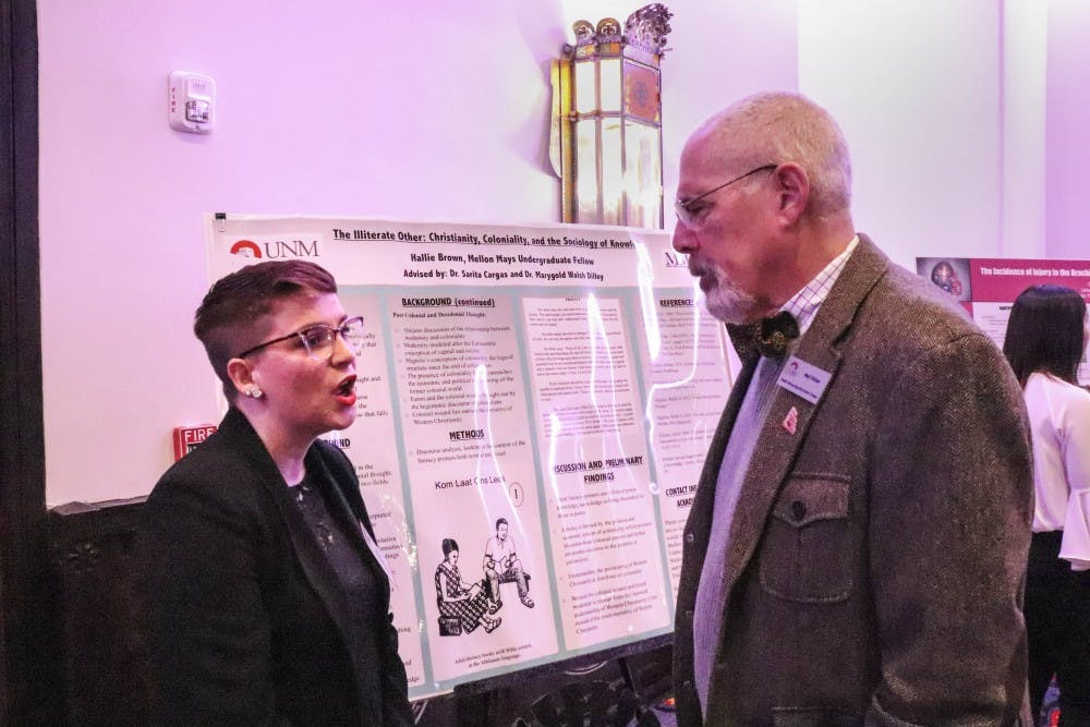 Hallie Brown explains her research to an attendee of the UNM Alumni-hosted appreciation dinner for sate lawmakers on Jan. 29, 2018.  