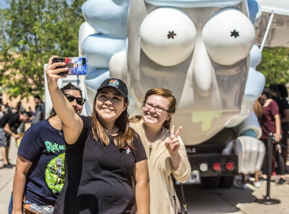 Left, Stephanie Romero, middle, Alysha White, right, Catherine Hernandez take a group selfie in front of the Rickmobile parked on Cornell Mall on Tuesday August 29th, 2017.  The Rickmobile is a road-tripping store front promoting merchandise for the Adult Swim cartoon Rick and Morty. The Don't Even Trip Road Trip Across America tour will also make a stop at Meow Wolf in Santa Fe, NM on Wednesday August 30th, 2017