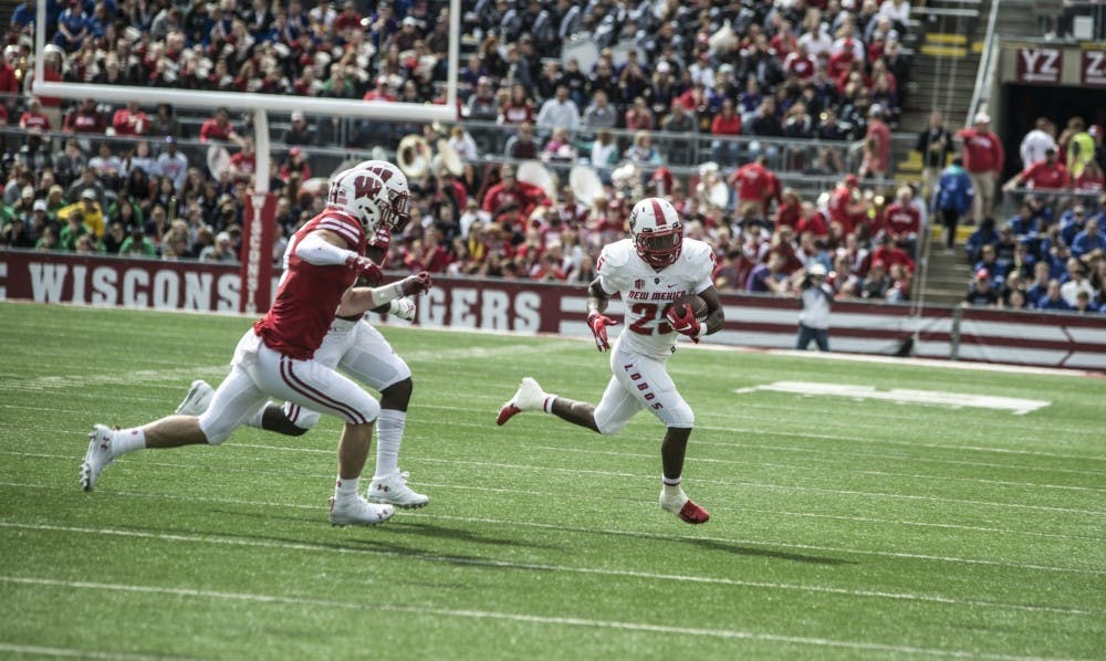 Tyrone Owens runs the ball with a pair of Wisconsin defenders in pursuit, Saturday at Camp Randall Stadium.
