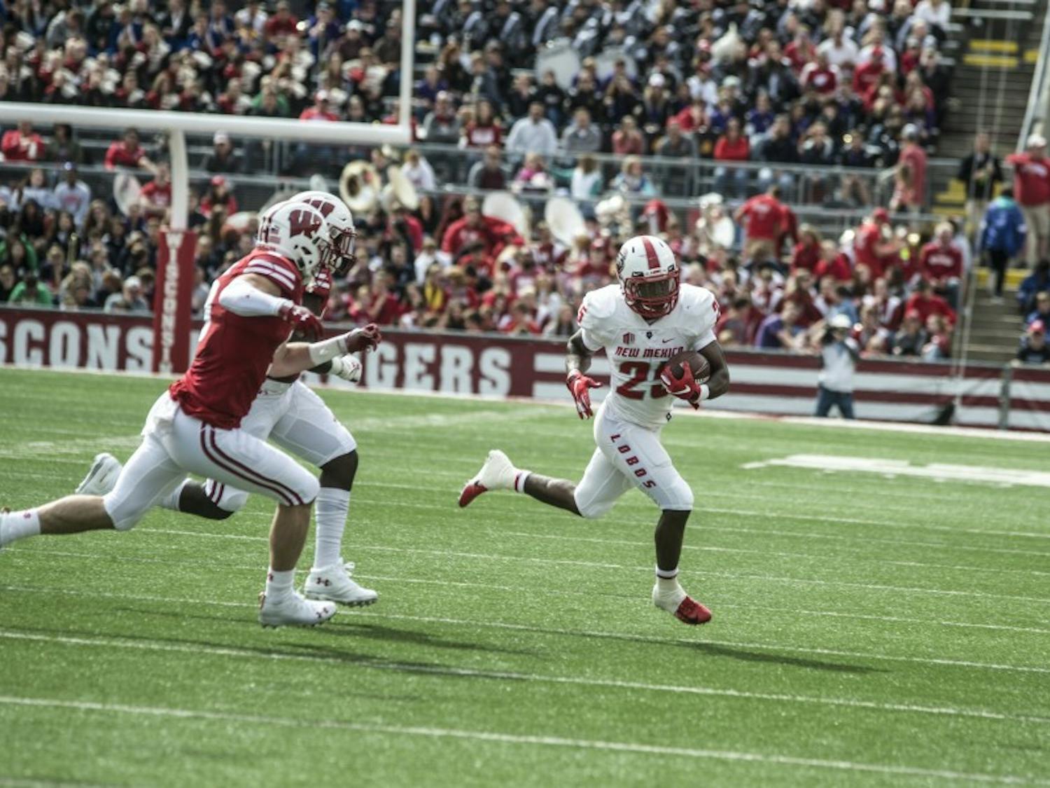 Tyrone Owens runs the ball with a pair of Wisconsin defenders in pursuit, Saturday at Camp Randall Stadium.