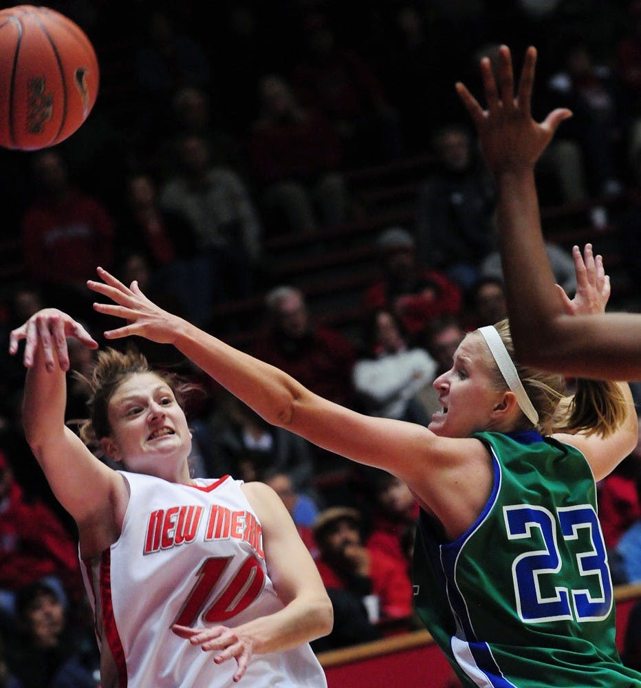 	Point guard Amy Beggin avoids Florida Gulf Coast’s Shannon Murphy while lofting a shot up on Sunday at The Pit. UNM coasted to an 80-64 win over the Eagles.