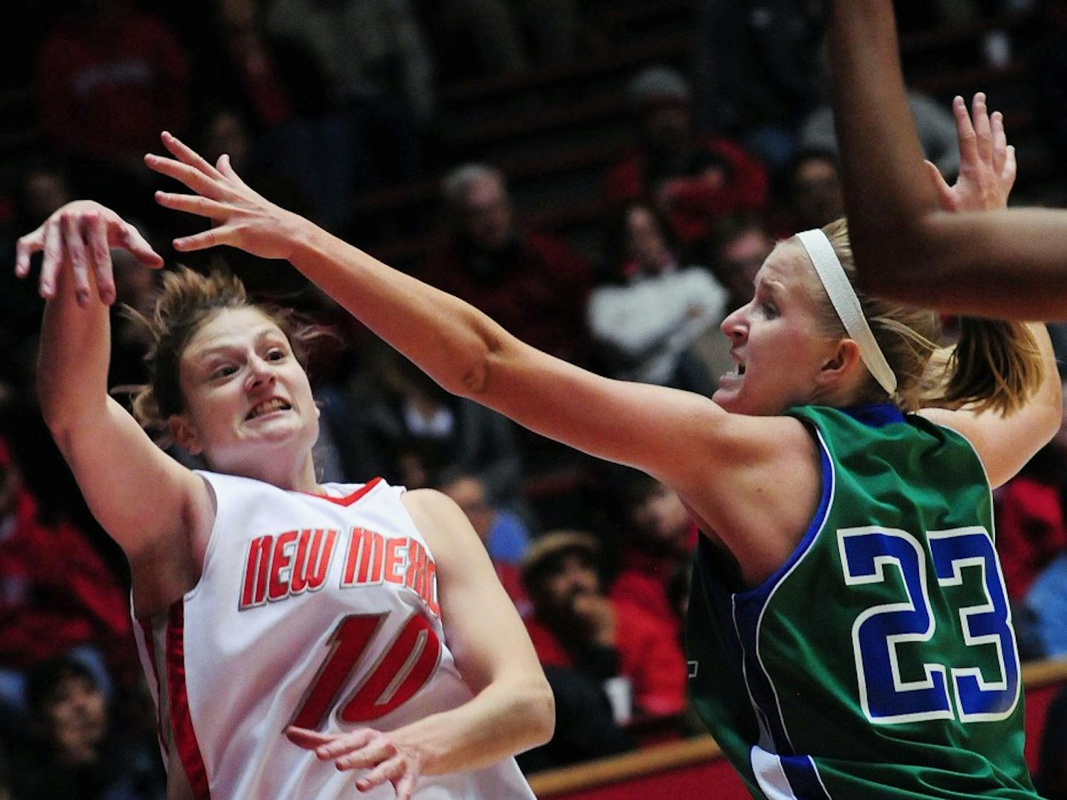 Point guard Amy Beggin avoids Florida Gulf Coast’s Shannon Murphy while lofting a shot up on Sunday at The Pit. UNM coasted to an 80-64 win over the Eagles.