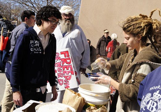 Tim Leyba, left, receives a bowl of soup from a Food Not Bombs representative, who wished to remain anonymous, on Wednesday in front of the Bookstore. 