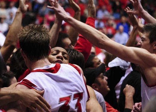 From left, Chad Toppert, Dairese Gary and Roman Martinez celebrate the Lobos' 77-71 win over Utah in The Pit on Tuesday. The victory puts UNM in a three-way tie for first place in the Mountain West Conference.