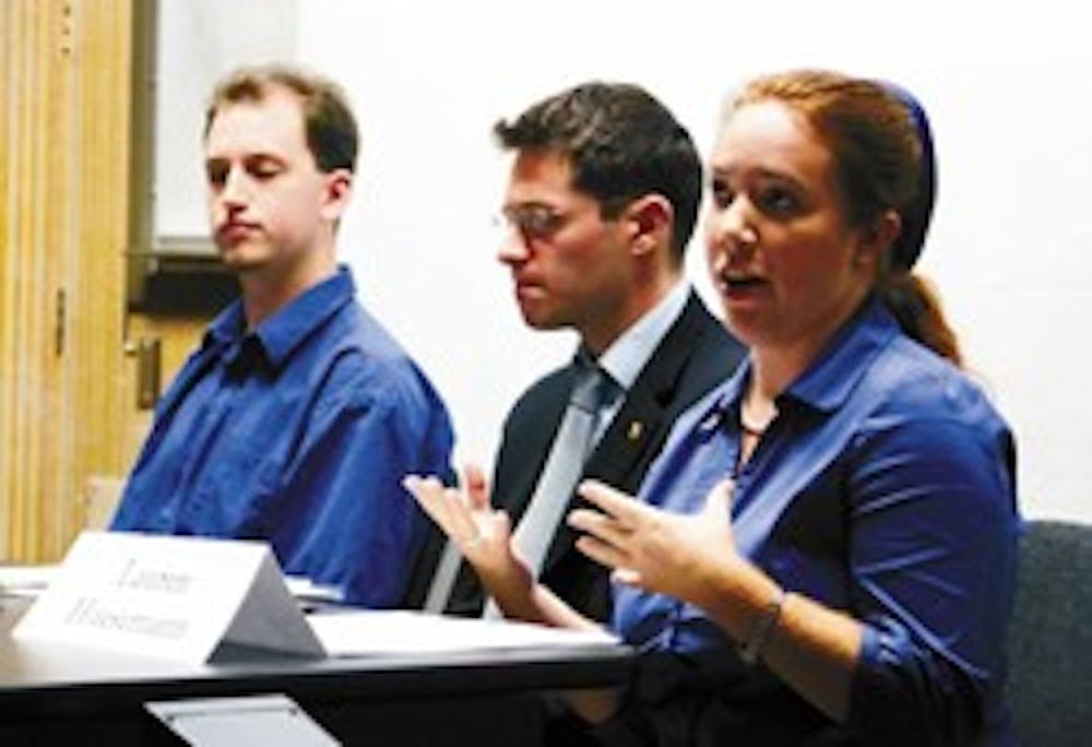 Lauren Huesemann, right, speaks while John Smeltzer, center, and Nick Engquist wait to answer a question during a panel discussion Wednesday at a lecture series on globalization in Woodward Hall.  