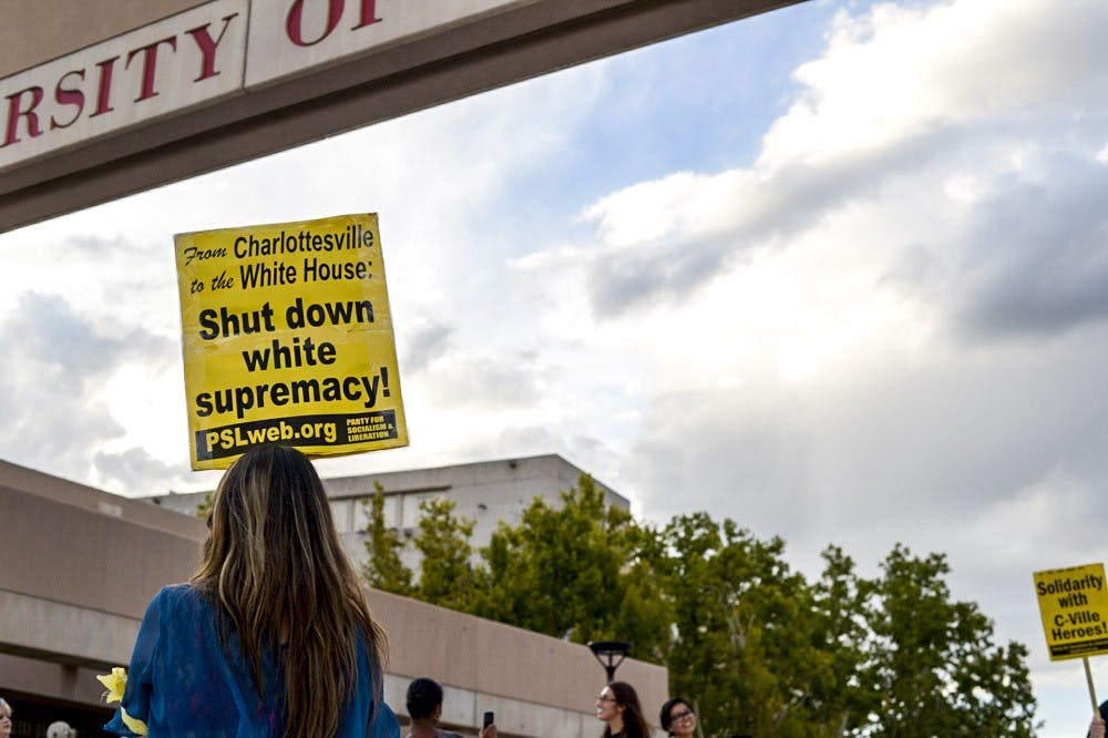 Protesters carried picket signs with messages of “Smash white supremacy,” “Bash bigotry” and “Solidarity with C-Ville heroes,” at an event organized by the Party for Socialism and Liberation outside the UNM Bookstore Sunday evening. The gathering was aimed to show support and solidarity for the victims of violent riots in Charlottesville, VA last weekend.