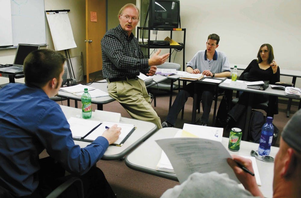 Instructor Doug Manz, center, talks to students Justin Crosby, left, and Eric Mechenbier during a portfolio management class Wednesday in the Anderson Schools of Management.