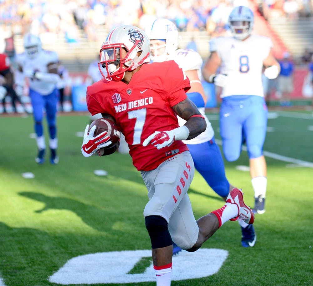 Lobos running back Teriyon Gipson runs past Tulsa defenders at University Stadium during their game Saturday night. The Lobos lost against the Golden Hurricane 21-40. 