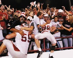 Lobo fans celebrate with Robert Turner, No. 59, and Thomas Wilson, No. 89, after UNM's 34-28 win over New Mexico State in Las Cruces on Saturday. 