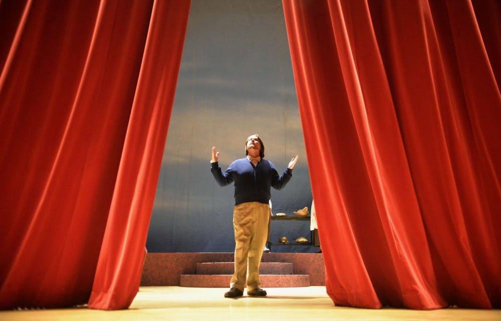 Eric Wilcox guides the main curtain during a rehearsal at Keller Hall on Monday. Wilcox is the narrator of “Tales from the Opera Crypt,” a play that features scenes from “Macbeth,” “Sweeney Todd” and “Into the Woods”.