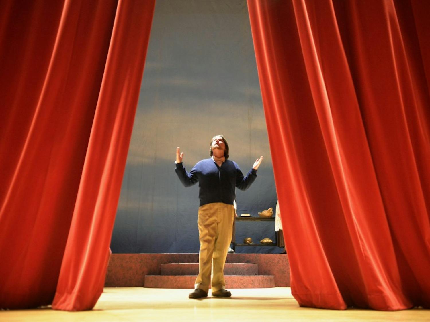 Eric Wilcox guides the main curtain during a rehearsal at Keller Hall on Monday. Wilcox is the narrator of “Tales from the Opera Crypt,” a play that features scenes from “Macbeth,” “Sweeney Todd” and “Into the Woods”.