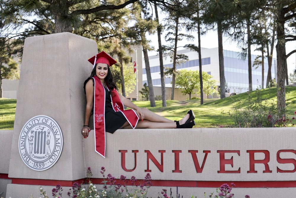 Marilyn Caro poses on the University of New Mexico sign for senior pictures on April 28, 2018. She graduates on May 12, with a double major in international studies and Spanish.