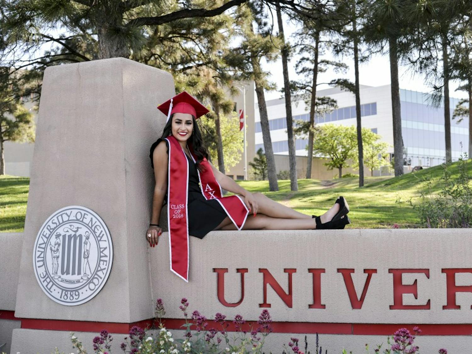 Marilyn Caro poses on the University of New Mexico sign for senior pictures on April 28, 2018. She graduates on May 12, with a double major in international studies and Spanish.