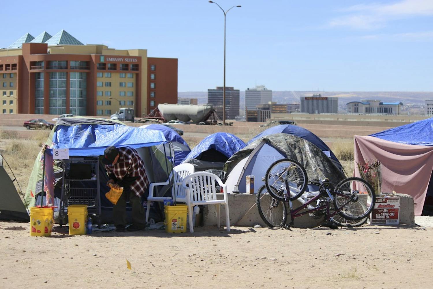 A Camp Resurrection resident relaxes outside his home on Monday afternoon. Residents of the previous tent cities have relocated to a plateau on the northeast corner of Lomas Boulevard and I-25. Residents of Camp Resurrection are awaiting city approval to make this area their permanent home. 