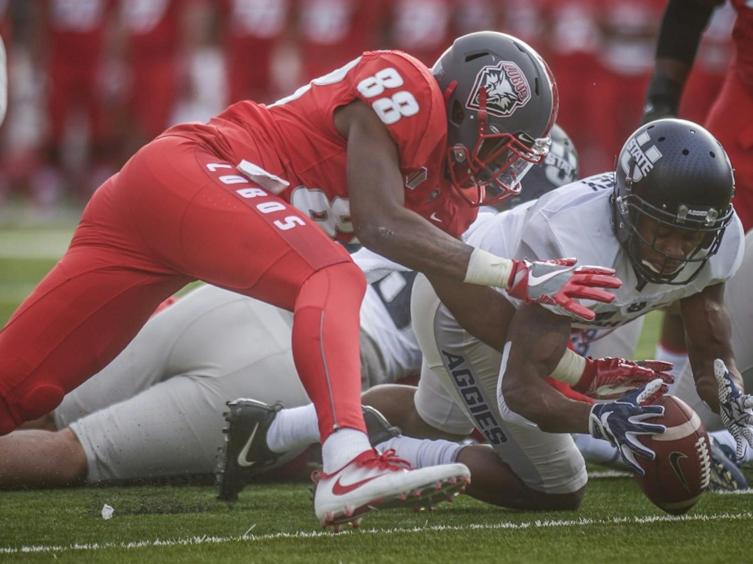Lobo tight end Marcus Williams and Aggie Cornerback Cameron Haney contest a loose ball after  Lobo quarterback Lamar Jordan&nbsp; fumbled in the 1st quarter, November 6, 2017. The Lobos were defeated by Utah State 24-10 at Dreamstyle Stadium.