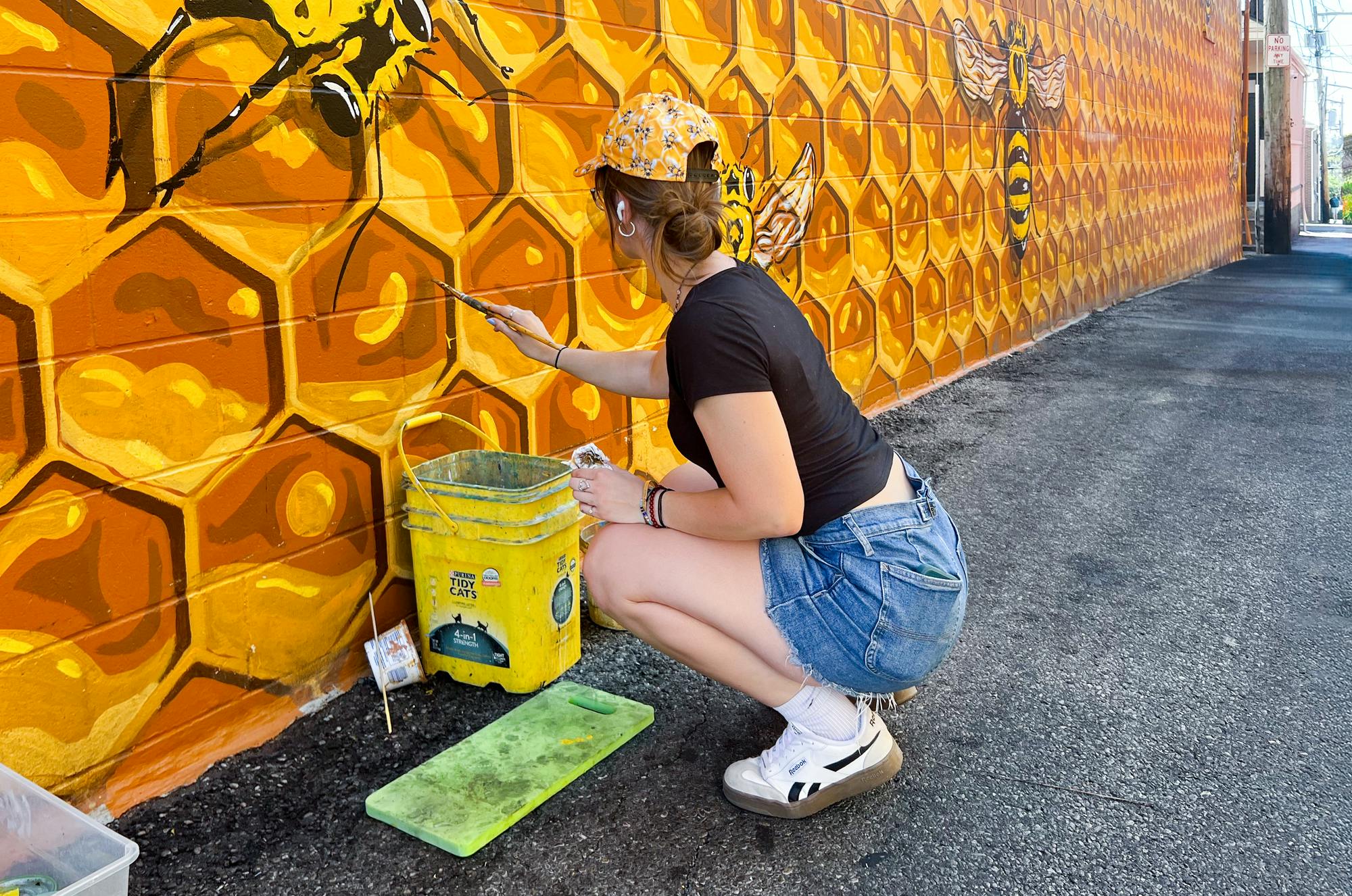 Painting student Ava Suarez helps refresh the mural in between classes.
