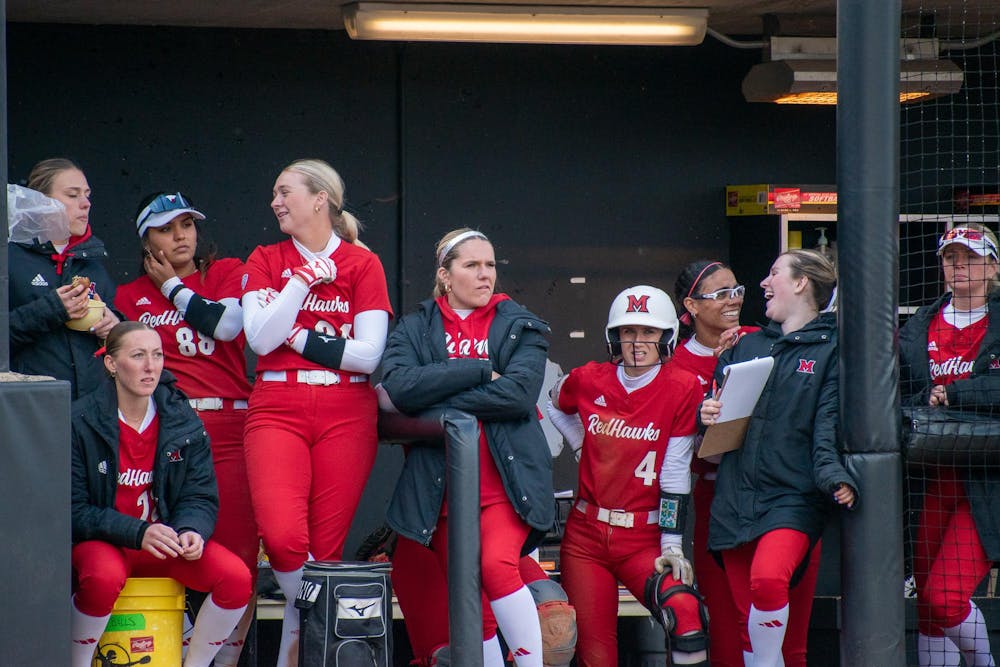 The 2024-25 softball team stands in the dugout during a game against Northern Illinois University. 
