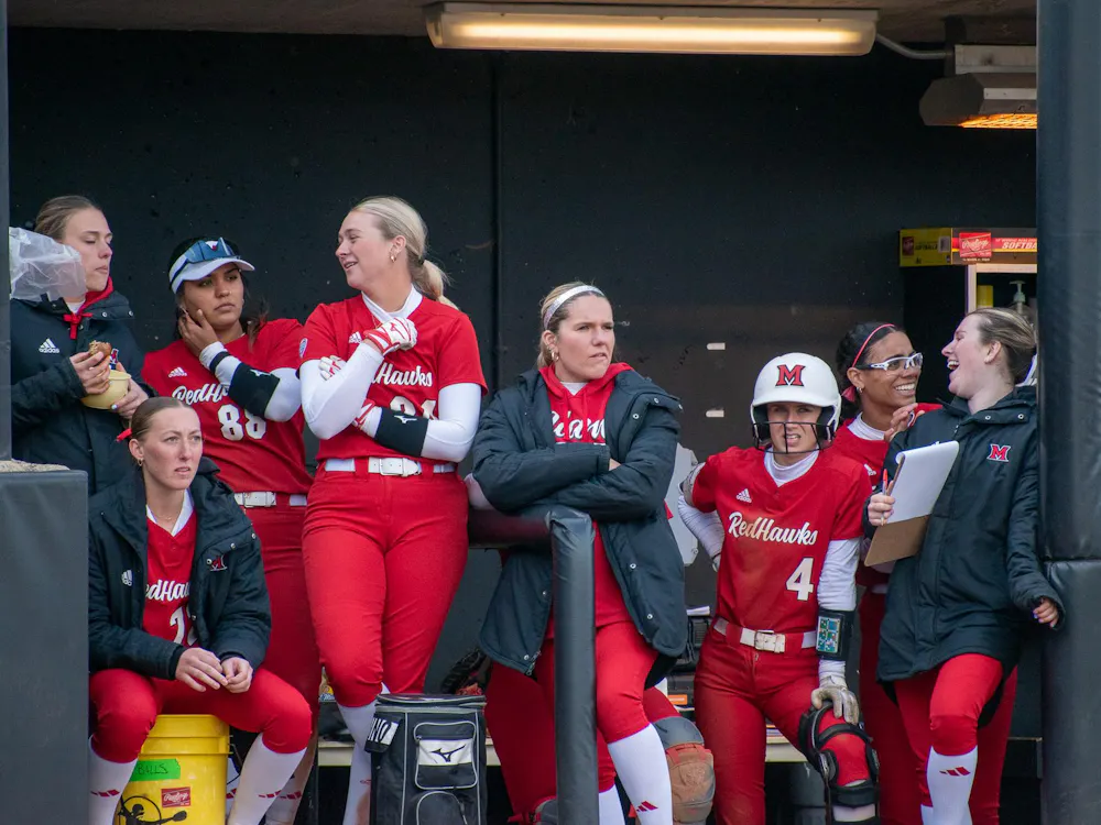 The 2024-25 softball team stands in the dugout during a game against Northern Illinois University.
