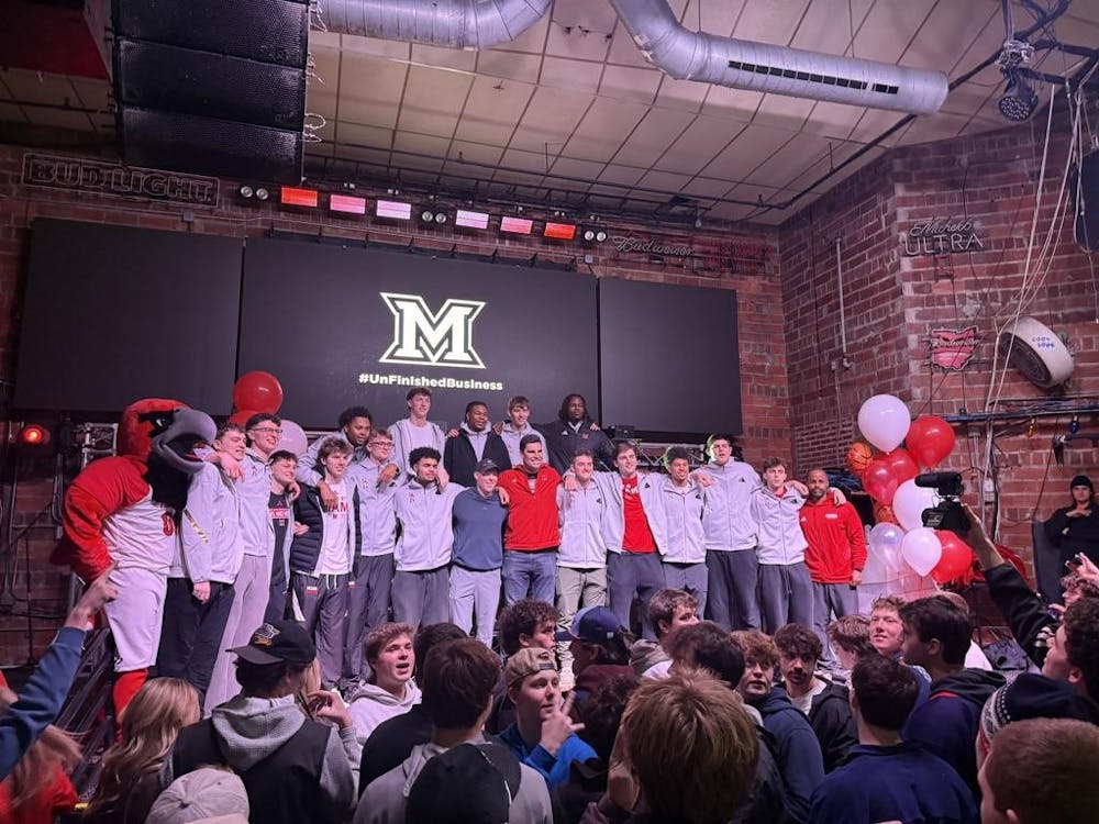 <p>The Miami men's basketball team poses with Wally Szczerbiak at Brick Street on Feb. 12</p>