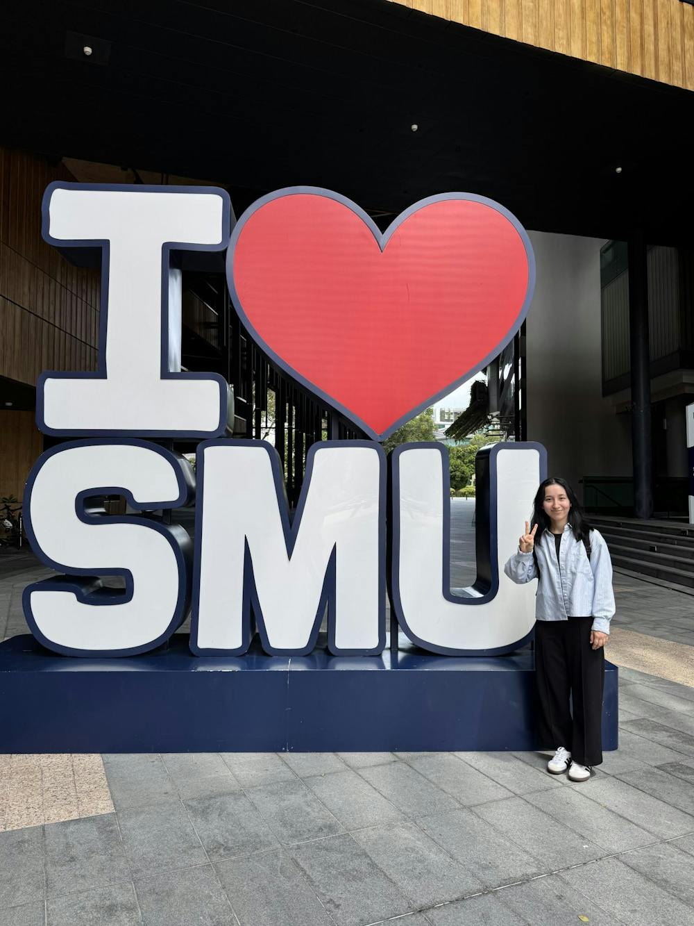 Mahfiza standing beside the “I <3 SMU” sign near the School of Economics, one of Singapore Management University’s eight distinct academic schools. Photo provided by Mahfiza Ashurova