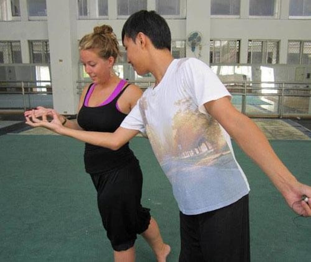 Shelby Becker works with a student at the National Taiwan College of Performing Arts.  Becker plays to implement aspects of her studies into the upcoming performance of The King and the Deer. 