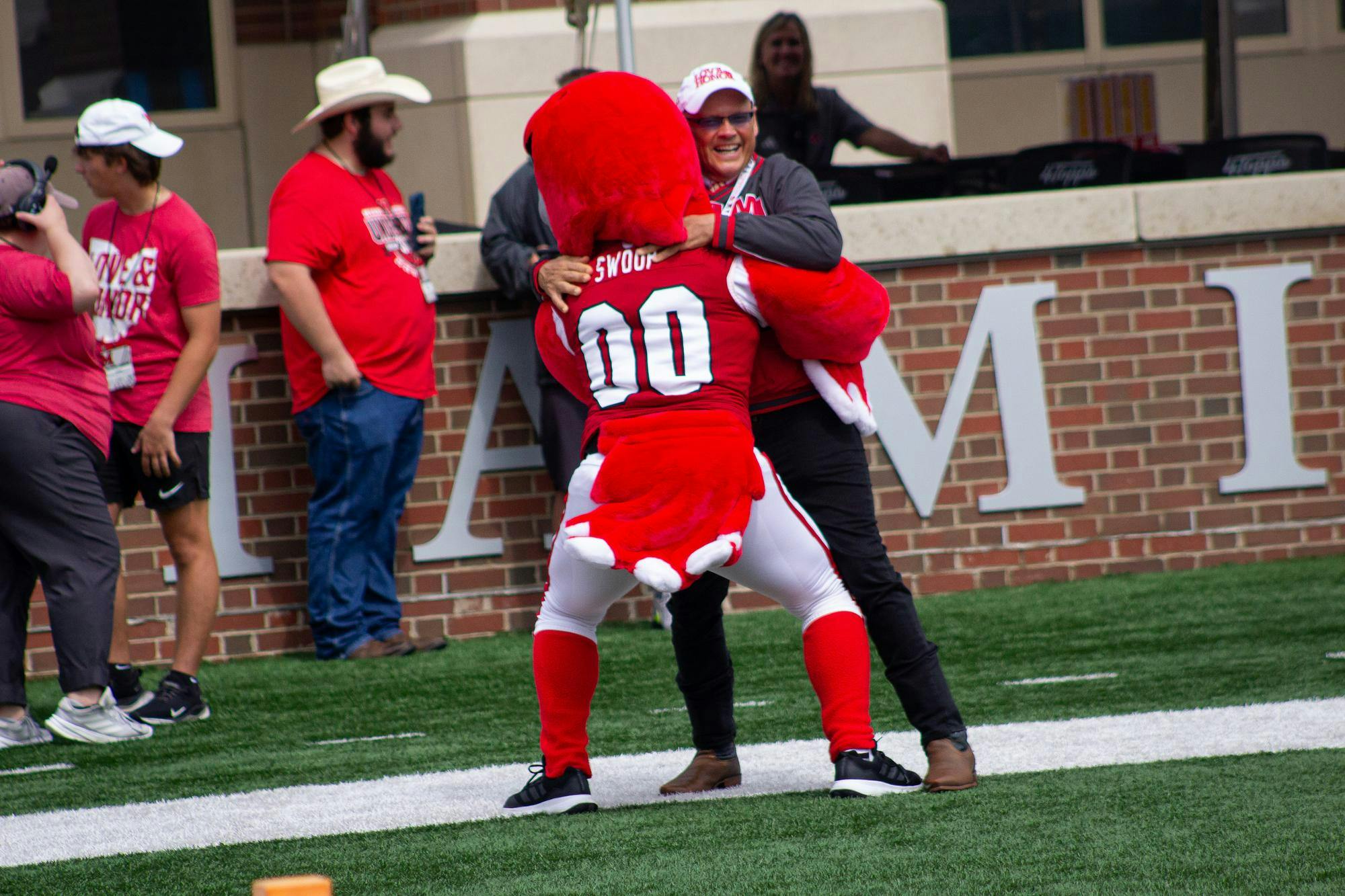 President Crawford embraces Swoop in endzone during game against the College of Holy Cross on Sept. 12. 