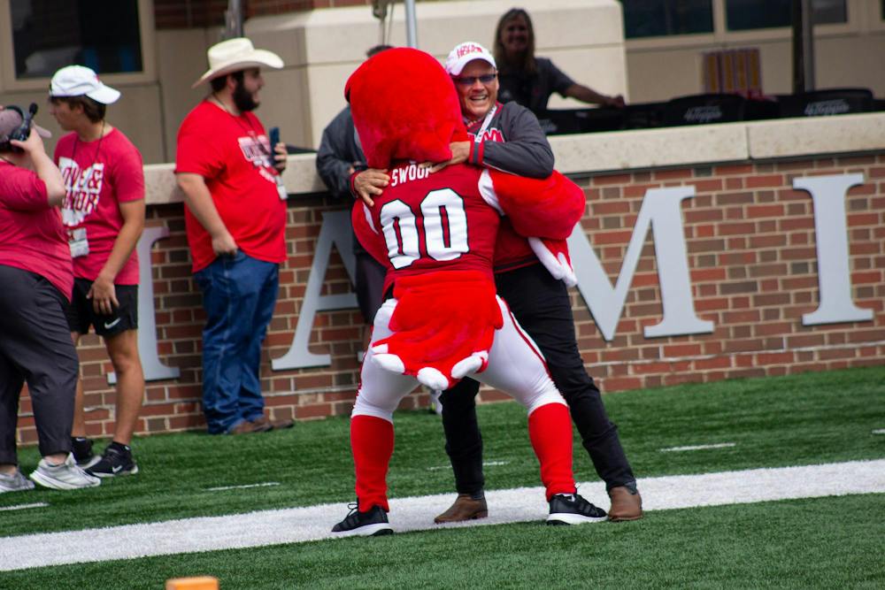 President Crawford embraces Swoop in endzone during game against the College of Holy Cross on Sept. 12. 