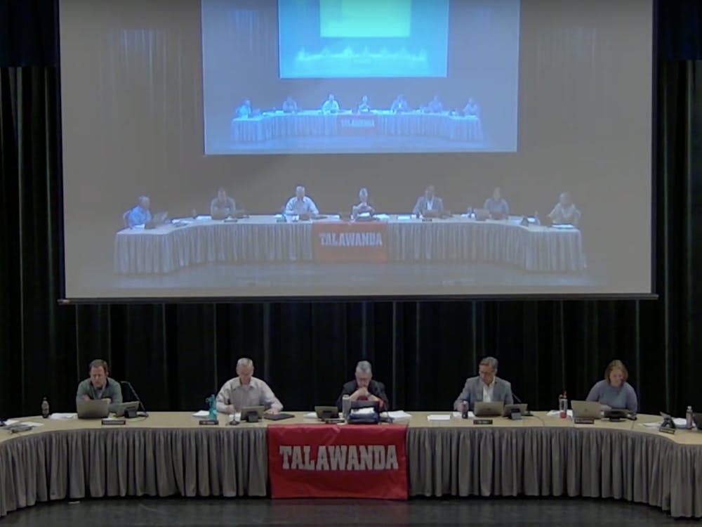 Talawanda school board members David Bothast, Pat Meade, Rebecca Howard, Chris Otto and Dawn King discuss potential district changes with superintendent Ed Theroux and treasurer Shaunna Tafelski seated on each end.
