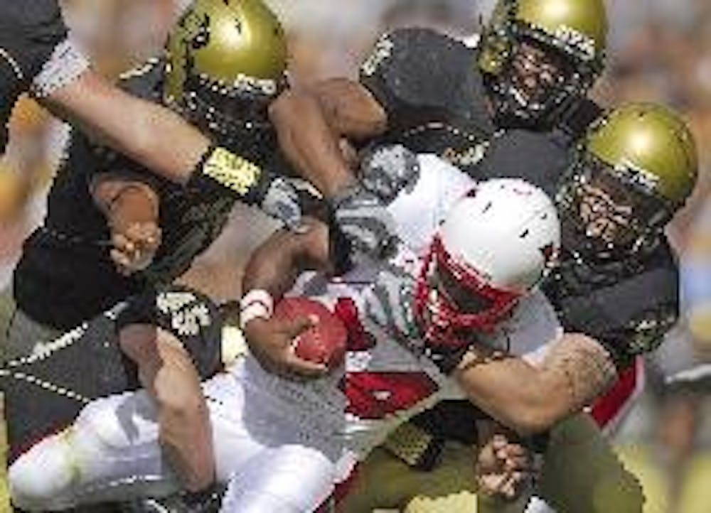 Miami's Thomas Merriweather gets up close and personal with five Colorado defenders as the RedHawks fell to Colorado, 42-0.  ZAK WOOD/The Colorado Daily