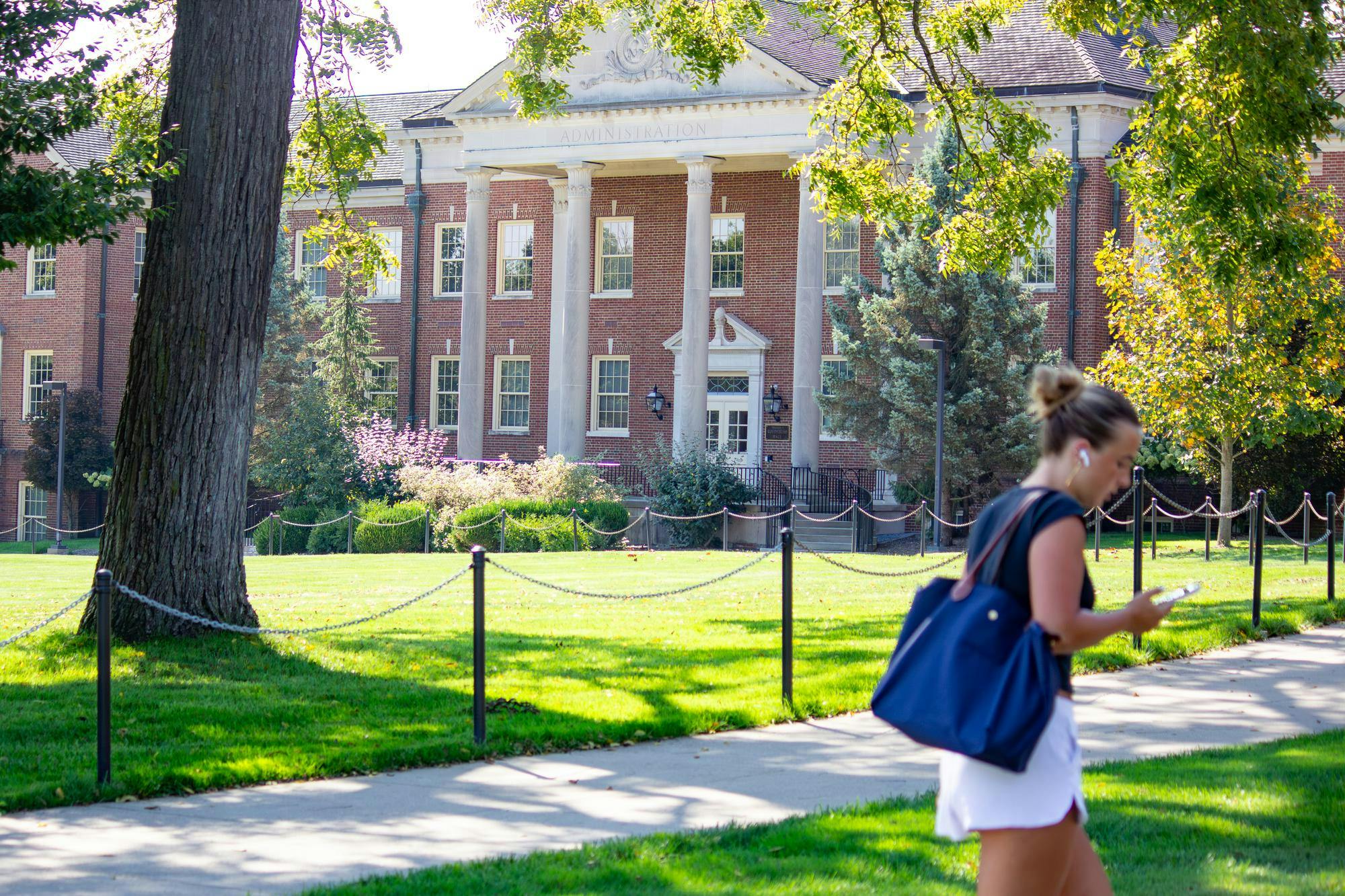 A student walks in front of Roudebush Hall which houses administrative departments.