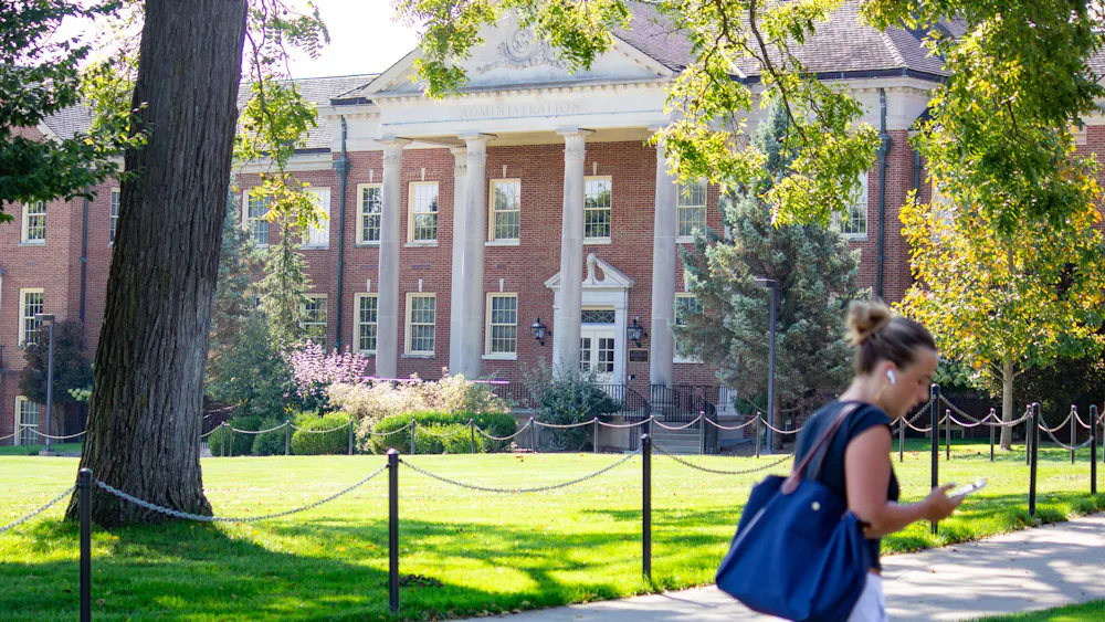 A student walks in front of Roudebush Hall which houses administrative departments.