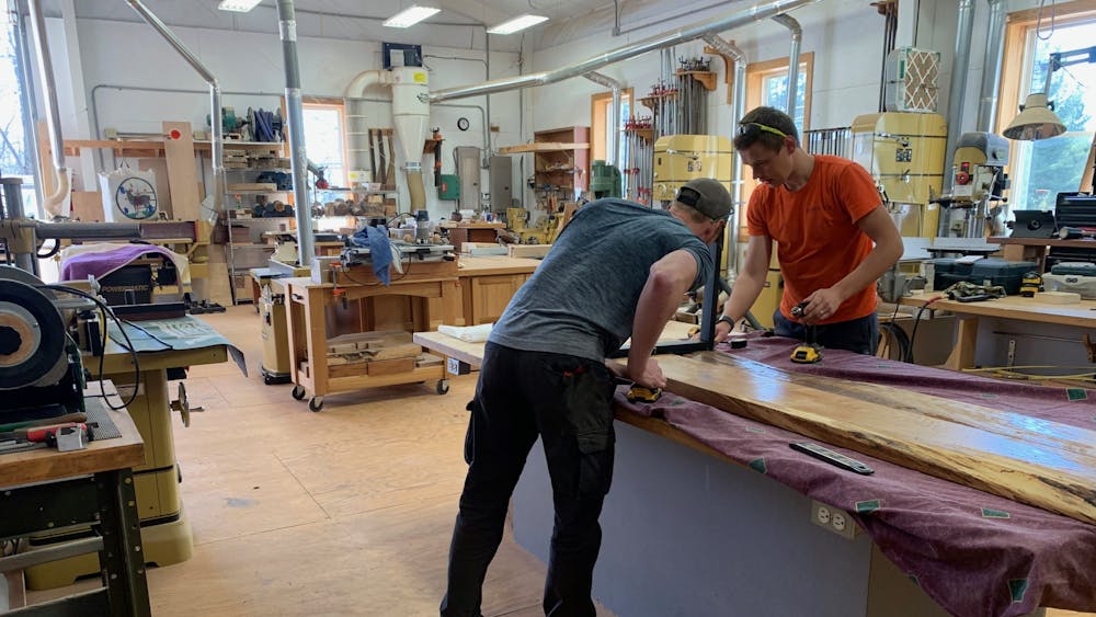 Ryan Murphy (left) and Vilppu Anttila (right) working on a bench to match the table they just finished. 