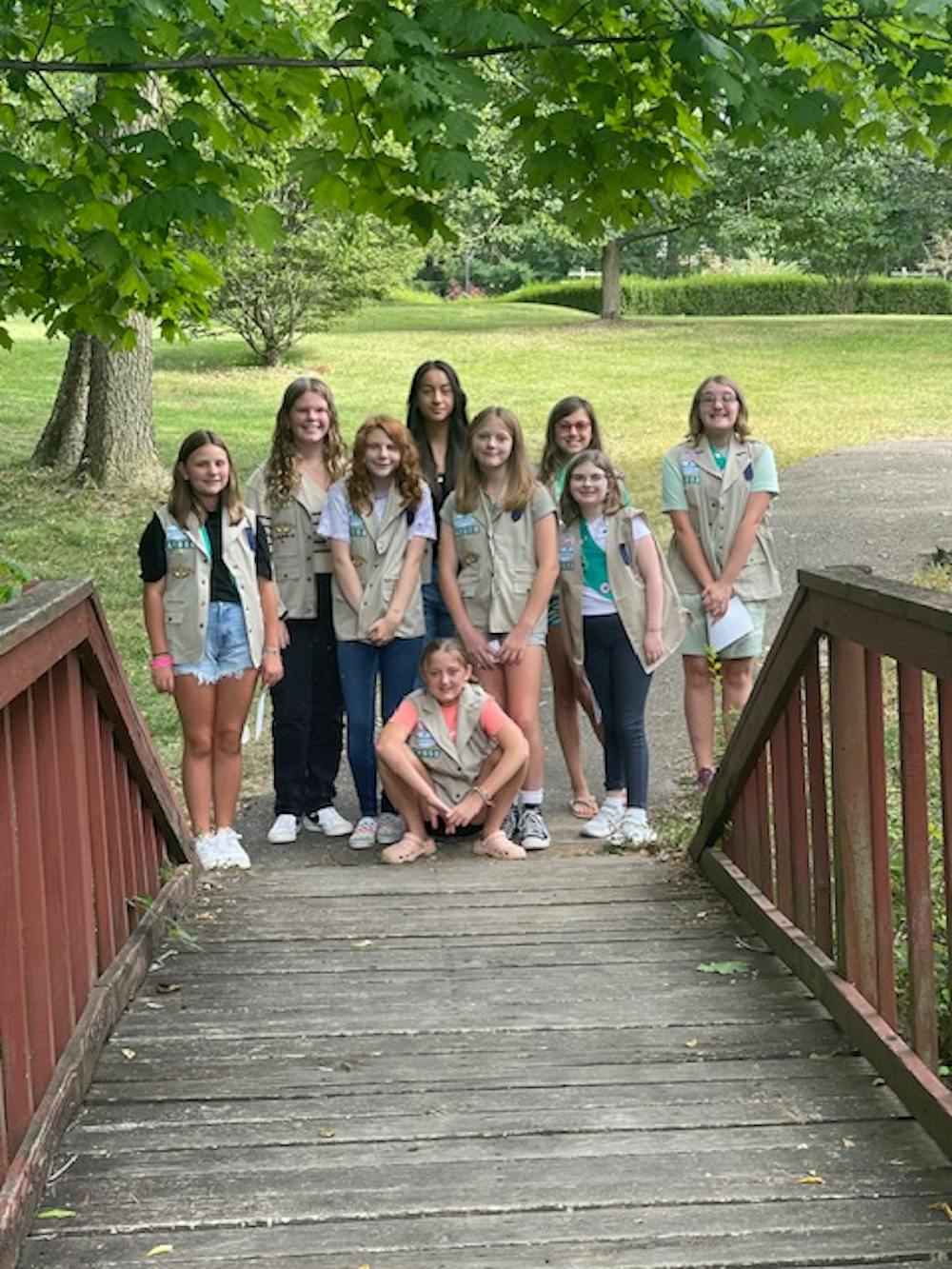 Girl scout troop 42058 poses for a photo in their vests. ﻿