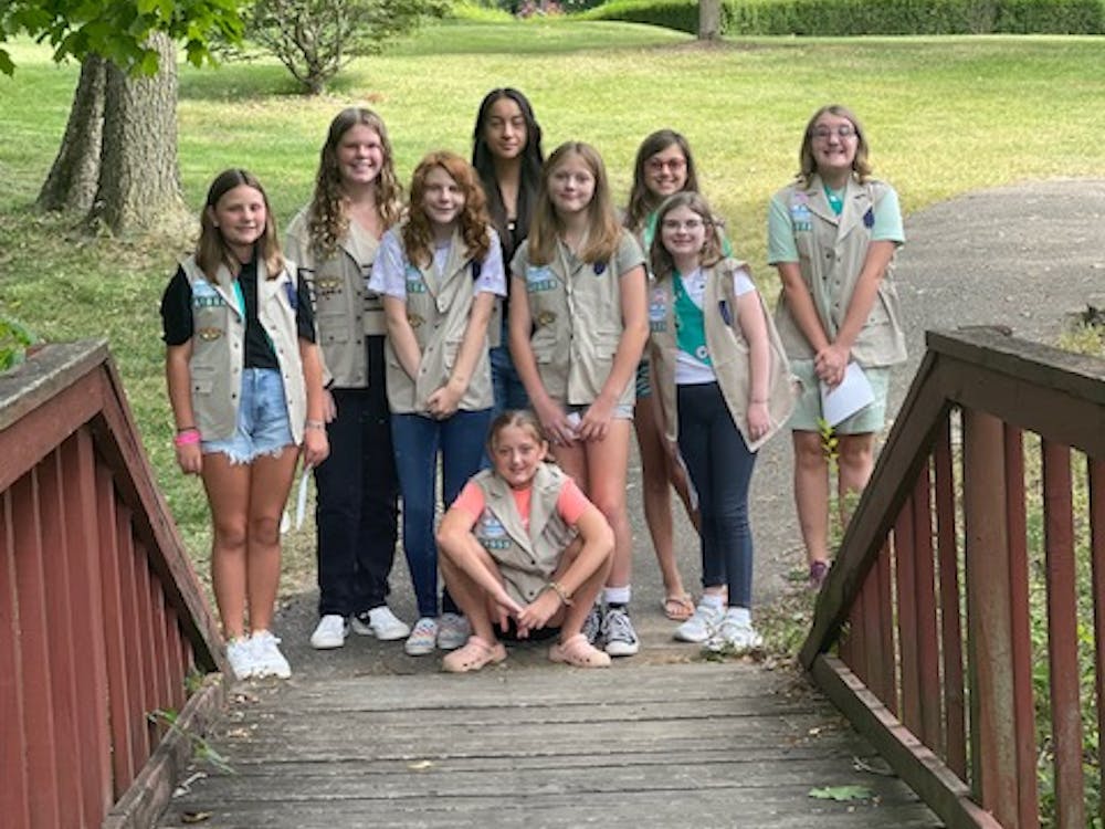 Girl scout troop 42058 poses for a photo in their vests. 