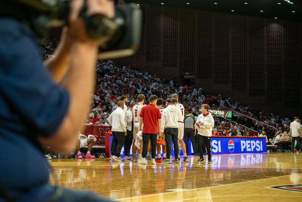 The Miami University RedHawks men's basketball team huddles in game against Ohio University.