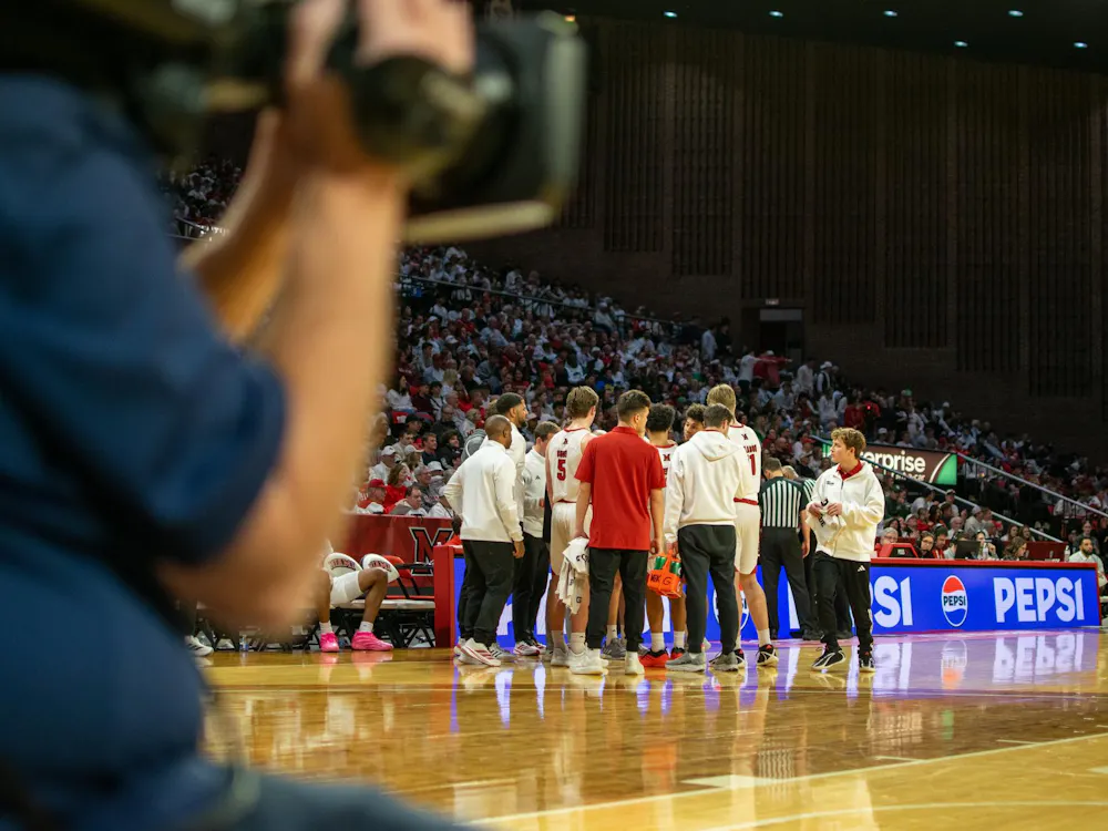 The Miami University RedHawks men's basketball team huddles in game against Ohio University.