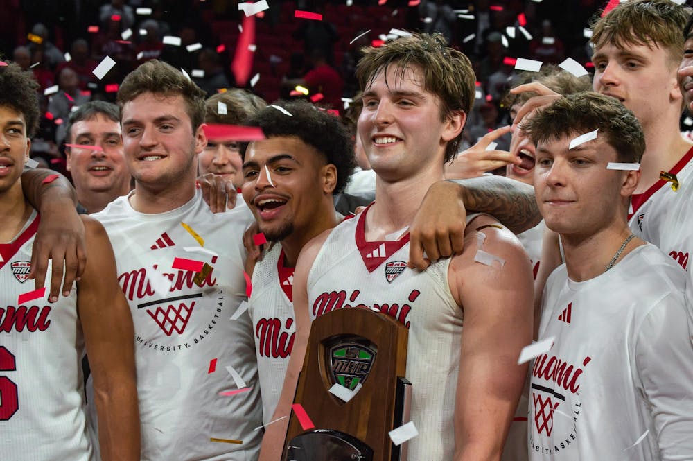 <p>Pete Suder stands along teamates with MAC champions trophy.</p>