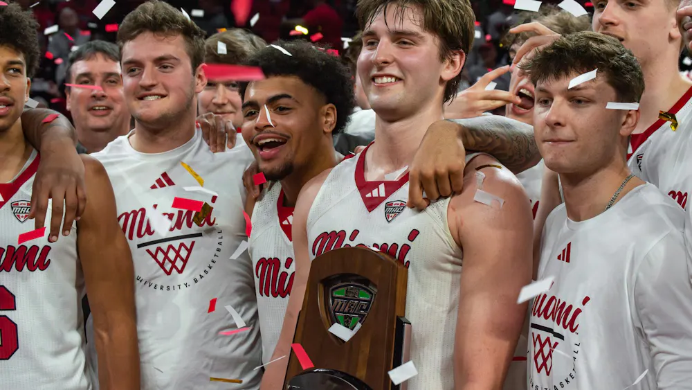 Pete Suder stands along teamates with MAC champions trophy.