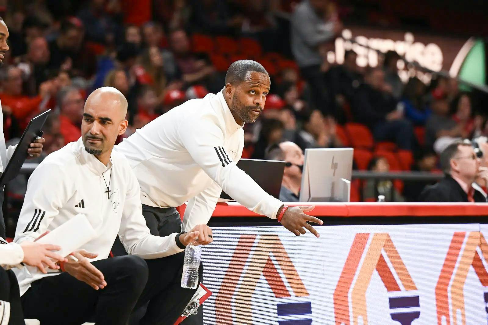 Assistant head coach Carl Richburg directs players from sideline of a Miami University RedHawks basketball game.
